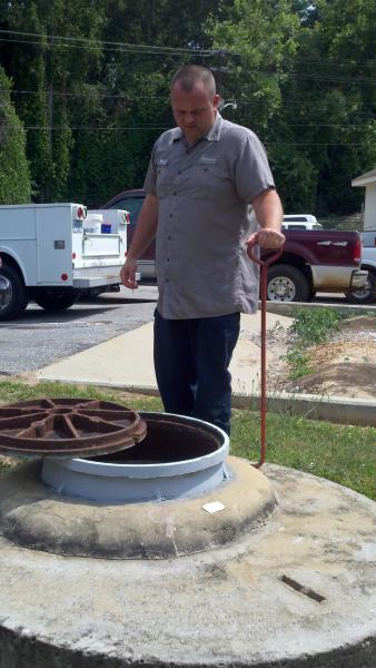 City Employee Inspecting Manhole